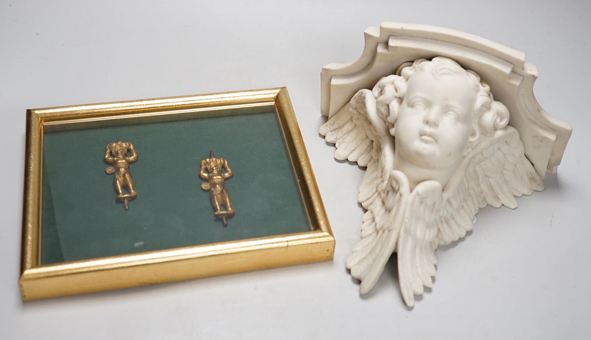 A pair of framed 17th / 18th century gilt-bronze putti mounts, each 7cm, and a 19th century parian 'cherub' bracket, 20cm high